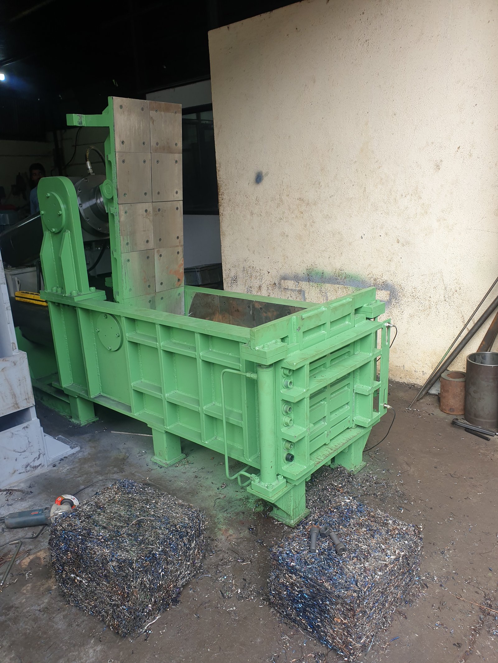 Green Hydraulic Baler Machine with compacted scrap wire bales, manufactured by Desire Hydraulics, Pune