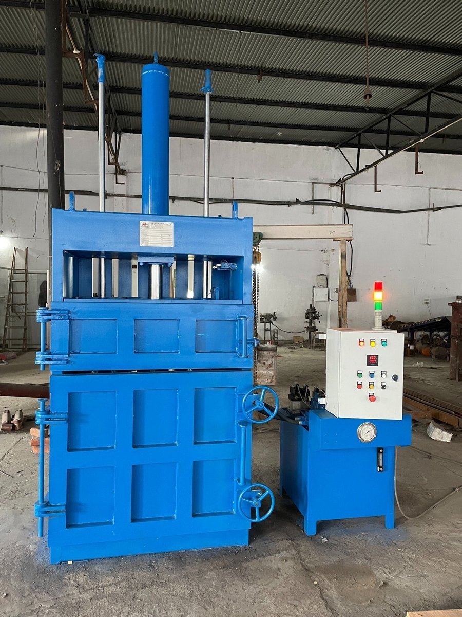 Hydraulic plastic baling machine with hand wheels and electrical control panel on the factory floor at Desire Hydraulics, Pune